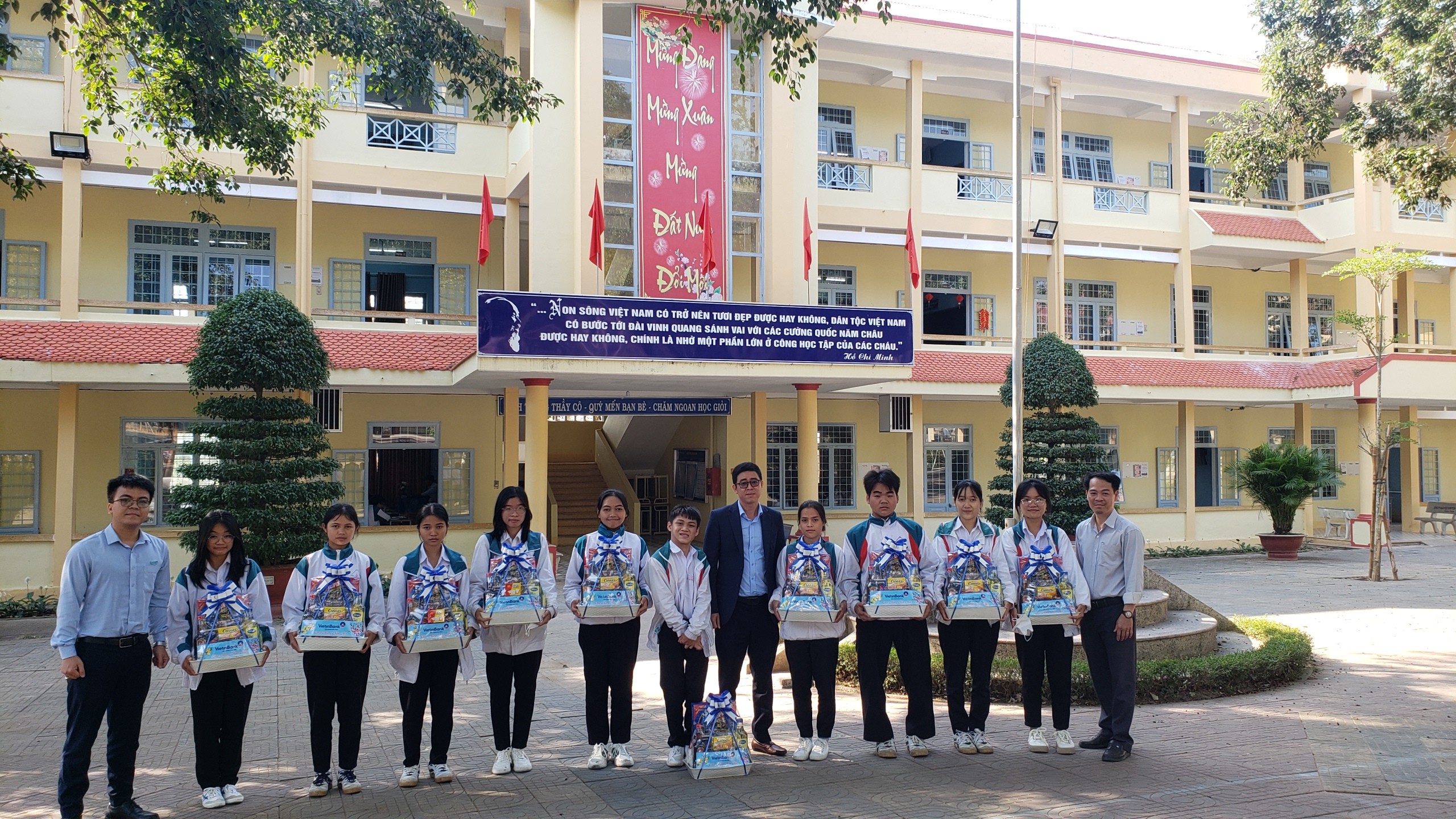 Ông Chinh (giữa) đại diện Ngân hàng Thương mại Cổ phần Công thương Việt Nam chi nhánh Ngọc Hồi tặng quà tết